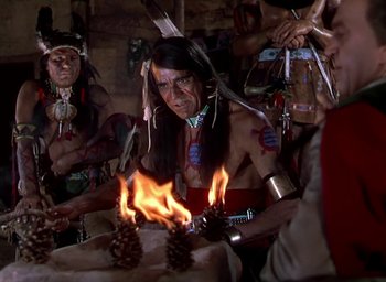 Movie still from “Unconquered” (1947), directed by Cecil B. DeMille – A group of native american men standing next to a fire; Medium shot, High angle