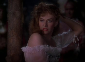 Movie still from “Unconquered” (1947), directed by Cecil B. DeMille – A beautiful woman in a white dress posing for a picture; Close Up shot, Over the shoulder angle