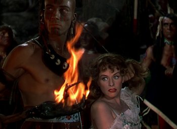 Movie still from “Unconquered” (1947), directed by Cecil B. DeMille – A man and a woman are standing in front of a fire; Medium shot, Over the shoulder angle