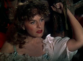 Movie still from “Unconquered” (1947), directed by Cecil B. DeMille – A beautiful woman in a white dress posing for a picture; Close Up shot, Over the shoulder angle