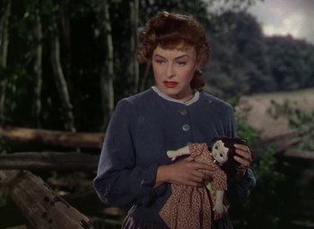 Movie still from “Unconquered” (1947), directed by Cecil B. DeMille – A woman holding a doll in her hands; Medium shot, Over the shoulder angle