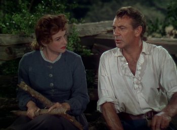 Movie still from “Unconquered” (1947), directed by Cecil B. DeMille – A man and a woman sitting next to each other on the ground; Medium shot, Over the shoulder angle