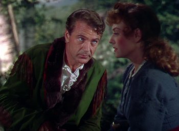 Movie still from “Unconquered” (1947), directed by Cecil B. DeMille – An older man and a younger woman are talking to each other; Medium shot, Over the shoulder angle