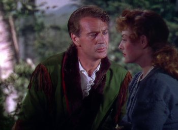 Movie still from “Unconquered” (1947), directed by Cecil B. DeMille – A man and a woman standing next to each other in front of trees; Medium shot, Over the shoulder angle