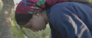 Movie still from “Under the Fig Trees” (2021), directed by Erige Sehiri – A young girl wearing a colorful head scarf; Close Up shot, Low angle