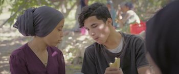 Movie still from “Under the Fig Trees” (2021), directed by Erige Sehiri – A young man and a young woman eating a sandwich; Close Up shot, Over the shoulder angle