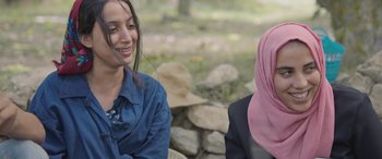 Movie still from “Under the Fig Trees” (2021), directed by Erige Sehiri – Two women are sitting outside talking to each other; Close Up shot, Over the shoulder angle