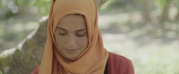 Movie still from “Under the Fig Trees” (2021), directed by Erige Sehiri – A person wearing a headscarf; Close Up shot, Low angle