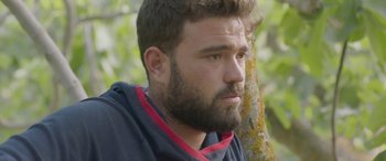 Movie still from “Under the Fig Trees” (2021), directed by Erige Sehiri – A person with a beard; Close Up shot, Low angle