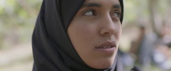 Movie still from “Under the Fig Trees” (2021), directed by Erige Sehiri – A person wearing a headscarf; Close Up shot, Low angle