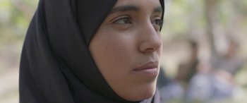 Movie still from “Under the Fig Trees” (2021), directed by Erige Sehiri – A person wearing a headscarf; Close Up shot, Low angle