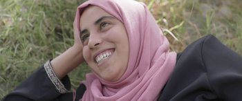 Movie still from “Under the Fig Trees” (2021), directed by Erige Sehiri – A person wearing a pink headscarf; Close Up shot, Low angle