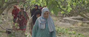 Movie still from “Under the Fig Trees” (2021), directed by Erige Sehiri – A group of women walking in a forest; Medium shot, Low angle