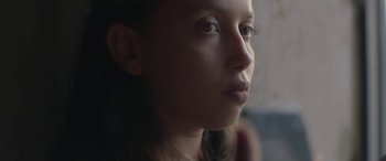 Movie still from “Under the Fig Trees” (2021), directed by Erige Sehiri – A person looking at the camera; Close Up shot, Low angle