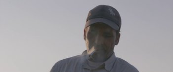 Movie still from “Under the Fig Trees” (2021), directed by Erige Sehiri – A person smoking a cigarette; Close Up shot, Low angle