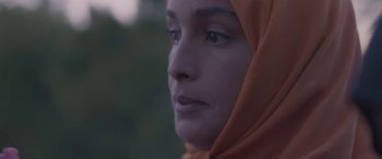 Movie still from “Under the Fig Trees” (2021), directed by Erige Sehiri – A person wearing a headscarf; Close Up shot, Low angle