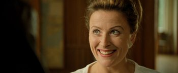 Movie still from “Under the Sun” (1998), directed by Colin Nutley – A person with green eyes smiling; Close Up shot, Over the shoulder angle