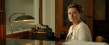 Movie still from “Under the Sun” (1998), directed by Colin Nutley – A woman sitting in front of an old fashioned typewriter; Close Up shot, Low angle