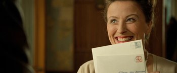 Movie still from “Under the Sun” (1998), directed by Colin Nutley – A woman holding a piece of paper in her mouth; Close Up shot, Over the shoulder angle