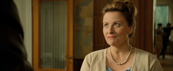 Movie still from “Under the Sun” (1998), directed by Colin Nutley – A person wearing a necklace; Close Up shot, Over the shoulder angle