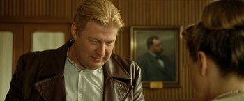 Movie still from “Under the Sun” (1998), directed by Colin Nutley – A person wearing a leather jacket; Close Up shot, Over the shoulder angle