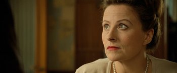 Movie still from “Under the Sun” (1998), directed by Colin Nutley – A person wearing a pearl necklace; Close Up shot, Low angle