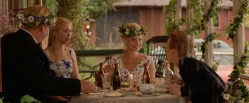 Movie still from “Under the Sun” (1998), directed by Colin Nutley – A group of people sitting at a dinner table; Medium shot, Over the shoulder angle