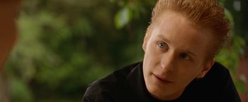 Movie still from “Under the Sun” (1998), directed by Colin Nutley – A person wearing a black shirt; Close Up shot, Over the shoulder angle