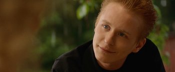 Movie still from “Under the Sun” (1998), directed by Colin Nutley – A person wearing a black shirt; Close Up shot, Over the shoulder angle