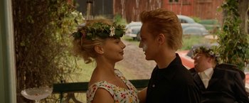 Movie still from “Under the Sun” (1998), directed by Colin Nutley – A man and a woman standing next to each other on a park bench; Close Up shot, Over the shoulder angle