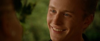 Movie still from “Under the Sun” (1998), directed by Colin Nutley – A person smiling for the camera; Close Up shot, Over the shoulder angle