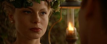 Movie still from “Under the Sun” (1998), directed by Colin Nutley – A person wearing a wreath of flowers; Close Up shot, Over the shoulder angle