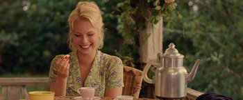 Movie still from “Under the Sun” (1998), directed by Colin Nutley – A woman sitting at a table in front of a tea pot; Medium shot, Over the shoulder angle
