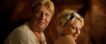 Movie still from “Under the Sun” (1998), directed by Colin Nutley – A man and a woman pose for a picture; Close Up shot, Low angle