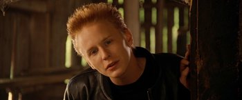 Movie still from “Under the Sun” (1998), directed by Colin Nutley – A man with blonde hair and a black jacket; Close Up shot, High angle