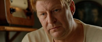 Movie still from “Under the Sun” (1998), directed by Colin Nutley – A man with blonde hair looking at the camera; Close Up shot, Low angle