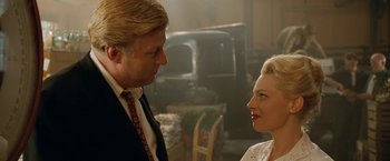 Movie still from “Under the Sun” (1998), directed by Colin Nutley – A man and a woman standing next to each other in a room; Close Up shot, Over the shoulder angle