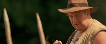 Movie still from “Under the Sun” (1998), directed by Colin Nutley – A man wearing a hat and holding a stick; Close Up shot, Over the shoulder angle