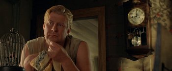 Movie still from “Under the Sun” (1998), directed by Colin Nutley – A man sitting in front of a mirror in a room; Close Up shot, Over the shoulder angle