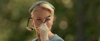 Movie still from “Under the Sun” (1998), directed by Colin Nutley – A woman holding a pair of scissors up to her face; Close Up shot, Over the shoulder angle