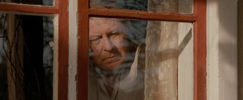 Movie still from “Under the Sun” (1998), directed by Colin Nutley – A man looking out of a window at the outside; Close Up shot, High angle