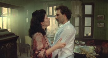Movie still from “Underground” (1995), directed by Emir Kusturica – A man and a woman standing next to each other in a room; Medium shot, Low angle