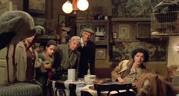 Movie still from “Underground” (1995), directed by Emir Kusturica – A group of people sitting at a table in a room; Wide shot, High angle