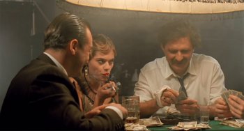 Movie still from “Underground” (1995), directed by Emir Kusturica – A group of people sitting around a table; Medium shot, Low angle