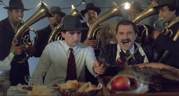 Movie still from “Underground” (1995), directed by Emir Kusturica – A group of people sitting at a table with horns on them; Medium shot, Low angle