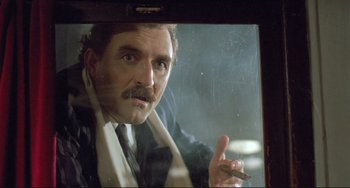 Movie still from “Underground” (1995), directed by Emir Kusturica – A person holding a cigarette in a car window; Close Up shot, Low angle