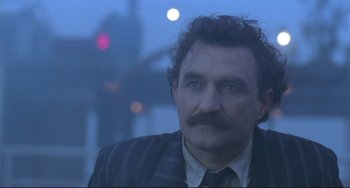 Movie still from “Underground” (1995), directed by Emir Kusturica – A person wearing a suit and tie; Close Up shot, Low angle