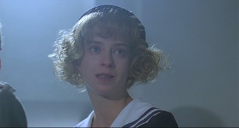 Movie still from “Underground” (1995), directed by Emir Kusturica – A young woman with blonde curly hair wearing a sailor suit; Close Up shot, Low angle