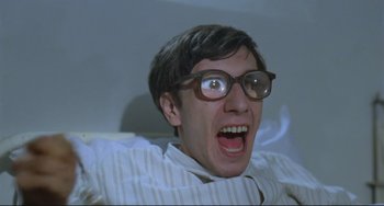 Movie still from “Underground” (1995), directed by Emir Kusturica – A young man wearing glasses and making a funny face; Close Up shot, Low angle