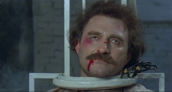 Movie still from “Underground” (1995), directed by Emir Kusturica – A man with a beard and a mustache is in a jail cell; Close Up shot, High angle